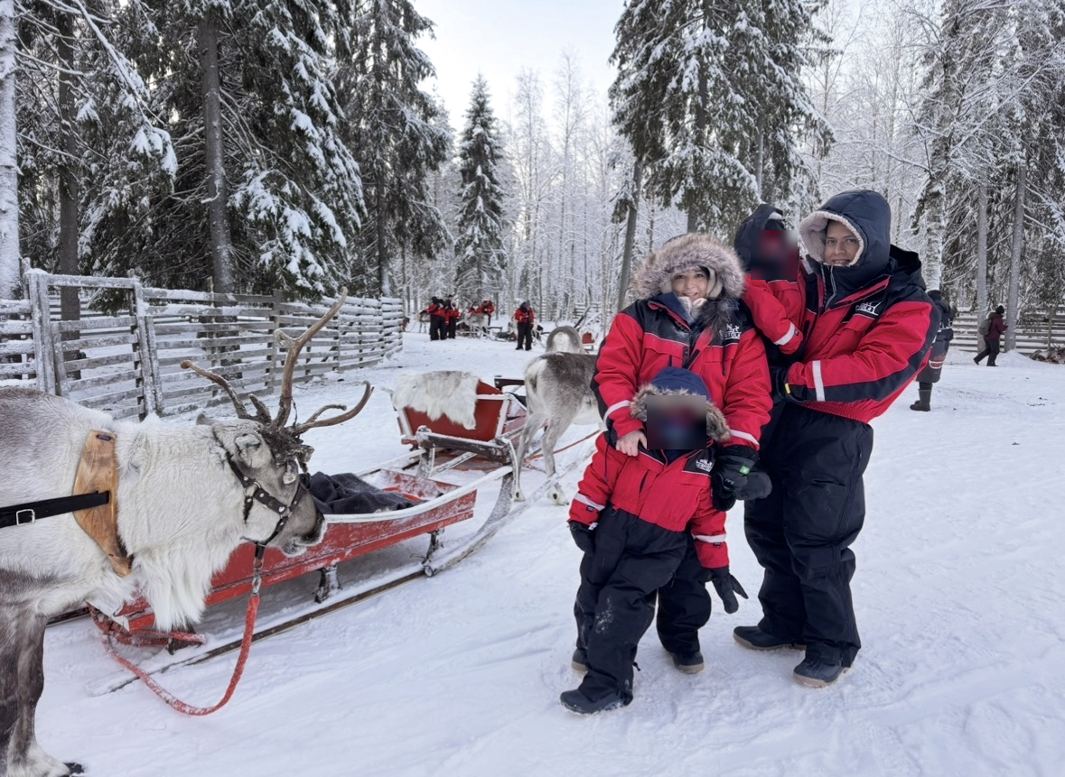 Lizi y su familia en la nieve junto a renos en Laponia, con los rostros de sus hijos difuminados